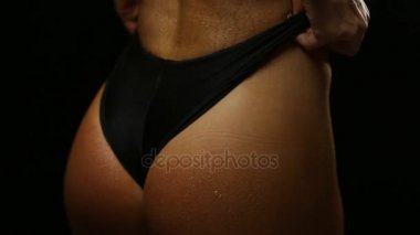 Flört genç siyah üzerine poz uygun kadın iç çamaşırı su ile damla vücudun hareket eder. Dikey kaydırma