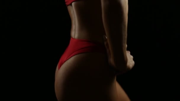 赤い水着が黒のポーズで若いフィット女性の体 垂直方向のパン — ストック動画
