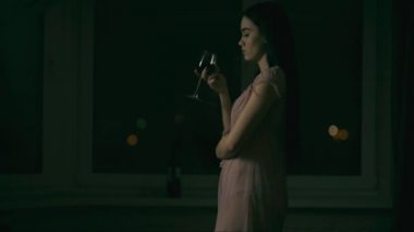 Genç bir kadın bir kadeh şarapla