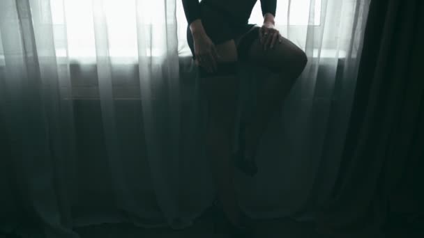 中年窓際のセクシーな衣装で挑発的な女性 垂直方向のパン — ストック動画
