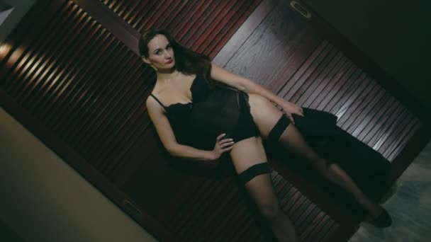 中年挑衅妇女在性感的服装与滚动相机调情附近的木制背景 — 图库视频影像
