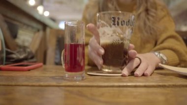 Barda likör ile bira içen bir kadın, sadece elleri görünüyor. Kiev, Ukrayna, 23 Kasım 2019