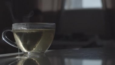 Buharlı bir fincan sıcak çay, sığ bir alan derinliği, yavaş çekim 120 fps. Kusursuz döngü