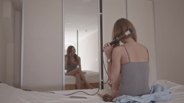 Młoda Kobieta Łóżku Sypialni Stylizacja Jej Włosy Patrząc Lustro Strzał — Wideo stockowe
