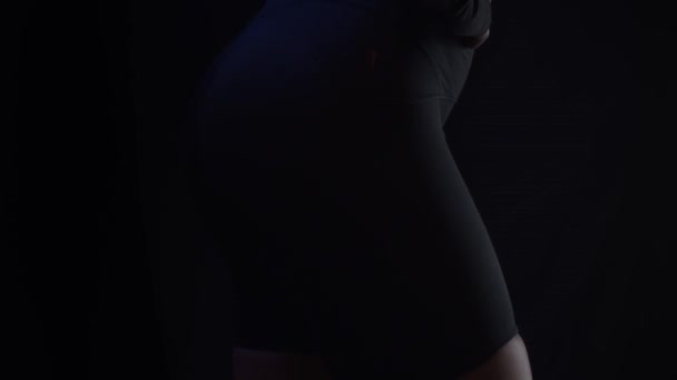 スポーツショートパンツの女性にフィットし 唯一の足が表示され スローモーションで撮影した 青い光を背中に動かす — ストック動画