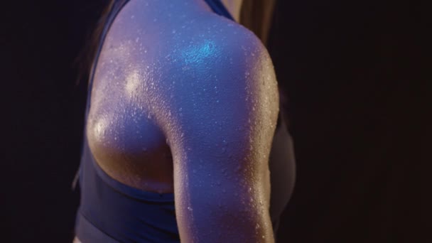 水の滴と色の光の下でフィット女性の腕の筋肉を閉じると スローモーションで撮影 — ストック動画