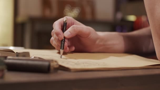 Mannelijke hand tekenen iets in notebook — Stockvideo