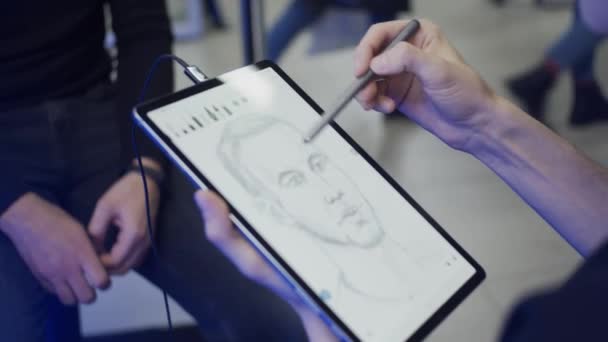 タブレットや電子ペンを使用して若い男の肖像画を描く スローモーション フィールドの浅い深さ — ストック動画