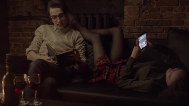 Ζευγάρι Στον Καναπέ Που Διαβάζει Βιβλία Και Μέσα Κοινωνικής Δικτύωσης — Αρχείο Βίντεο