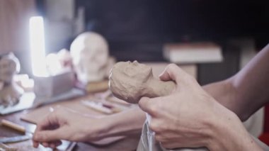 Plastikçili kadın büstü (kurutulmayan kil) yapan genç sanatçı)