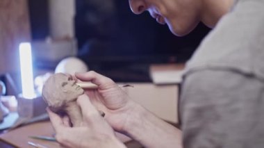 Plastikçili kadın büstü (kurutulmayan kil) yapan genç sanatçı)