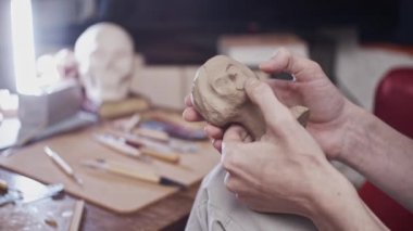 Plastikçili kadın büstü (kurutulmayan kil) yapan genç sanatçı)