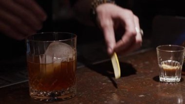 Alkol kokteyli yapma süreci, sıkma portakal kabuğu cam, yavaş çekim, sığ alan derinliği