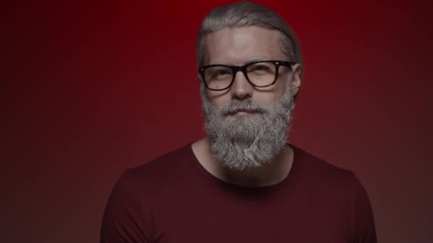 Gözlüklü Gri Saçlı Adam Kameraya Kırmızı Parıltı Üflüyor Yavaş Çekim — Stok video