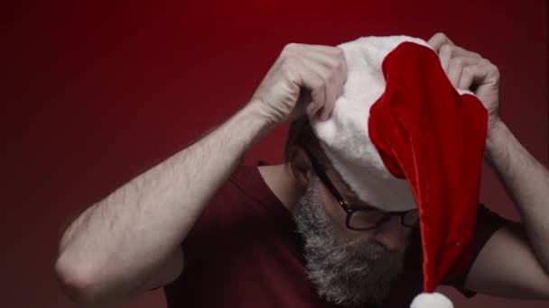 Portret Świętego Mikołaja Zakładający Kapelusz Czerwone Tło Zwolniony Ruch — Wideo stockowe