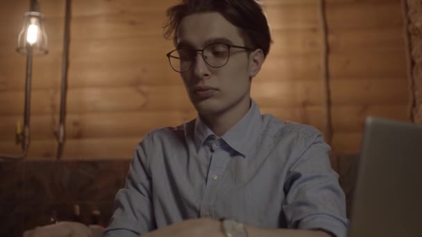 Молодой Человек Работает Ноутбуком Слушает Музыку Помощью Наушников Замедленной Съемки — стоковое видео