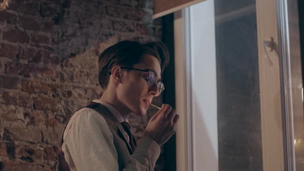 Junger Mann Klassischer Kleidung Raucht Neben Fenster Und Ziegelmauer Zeitlupe — Stockvideo