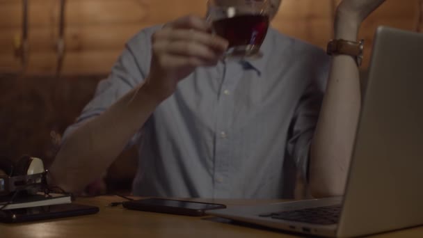 Genç adam dizüstü bilgisayarla çalışıyor ve çay içiyor. — Stok video