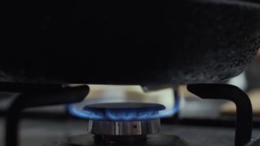 Gaz ocağı alevi kızartma tavasının altında, yavaş çekim, sığ alan derinliği