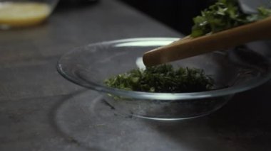 Mutfakta yeşillikler kesiliyor. Yakın çekim, yavaş çekim.