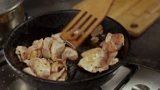 フライパンで鶏の肉を木製のシャベルで混ぜ フィールドの浅い深さ スローモーション — ストック動画