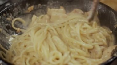 Spagettiyi tavuklu etle karıştırmak, yavaş çekim, sığ alan derinliği