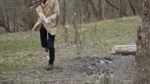 若い男は木の棒で空のボトルを破る 怒りの管理の概念 スローモーション — ストック動画