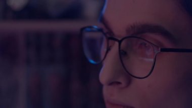Bilgisayarda çalışan gözlüklü genç adam, gözlüklü monitörün yansıması, yavaş çekim, sığ alan derinliği