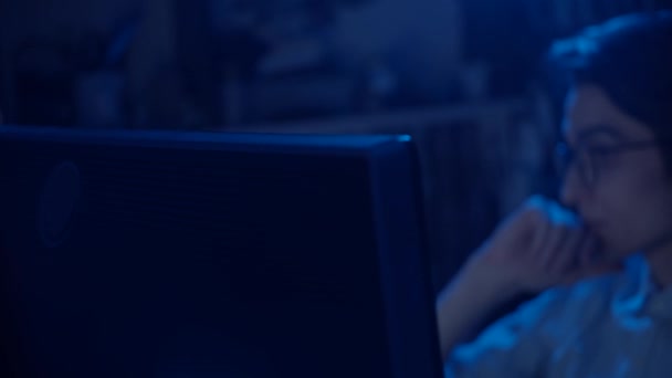Jeune homme à lunettes travaillant à l'ordinateur, réflexion du moniteur à lunettes, ralenti, faible profondeur de champ 