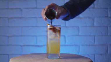 Kokteyl bardağına içki doldurmak, ağır çekim.