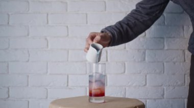 Kokteyl bardağına içki doldurmak, ağır çekim.