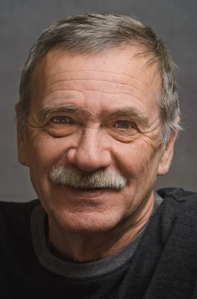 Portrait of an elderly man with a kind smile. — Stock Photo, Image