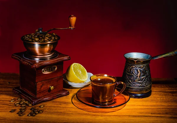 A Cup of coffee, lemon, boiling water and manual coffee grinder — Stock Photo, Image