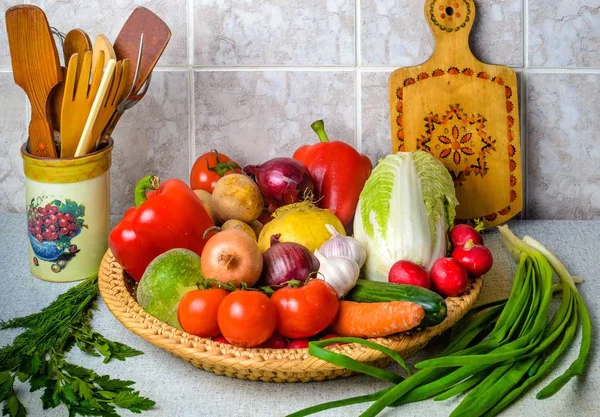 Sur la table de cuisine, dans le grand panier en osier sont une variété o — Photo