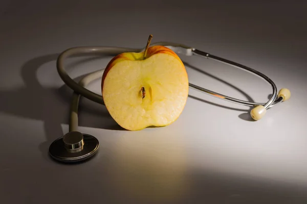 Stetoscopio su un piano generale e un frammento di una grande mela . — Foto Stock