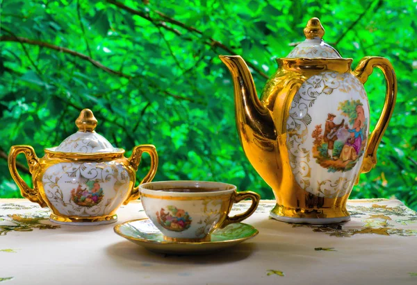 On the background of green foliage, graceful coffee set of three — Stock Photo, Image