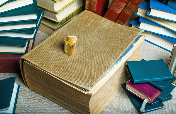 Close-up: very large, thick old book, and it is very small is al