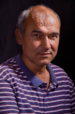 Portrait of a young tanned Asian man on a black background