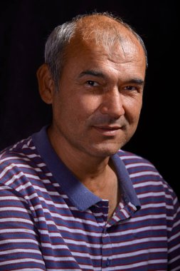 Portrait of a young tanned Asian man on a black background