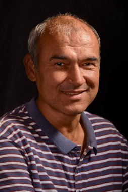 Portrait of a young tanned Asian man on a black background