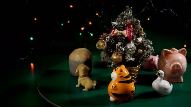 Animals toys in a round dance around a toy Christmas tree Rotation. — Stock Video
