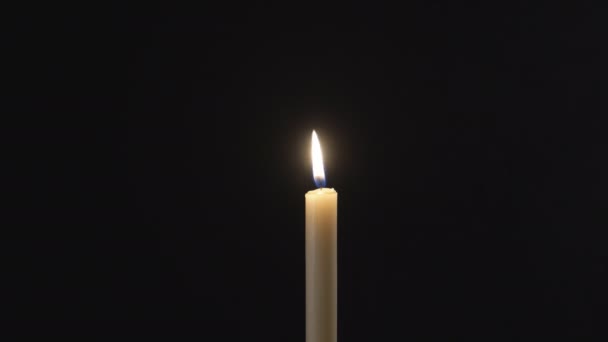 Рука закрывает пламя свечи от порывов ветра — стоковое видео