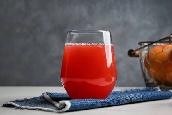 Vaso con delicioso jugo de cítricos en la mesa —  Fotos de Stock