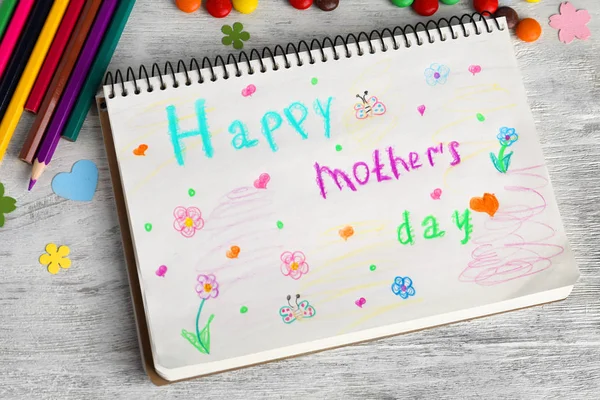 Anteckningsbok med orden ”glad mors dag” på trä bakgrund — Stockfoto