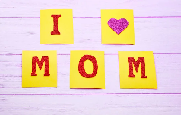Phrase I LOVE MOM faite de notes collantes sur fond en bois. Salutations pour la fête des mères — Photo