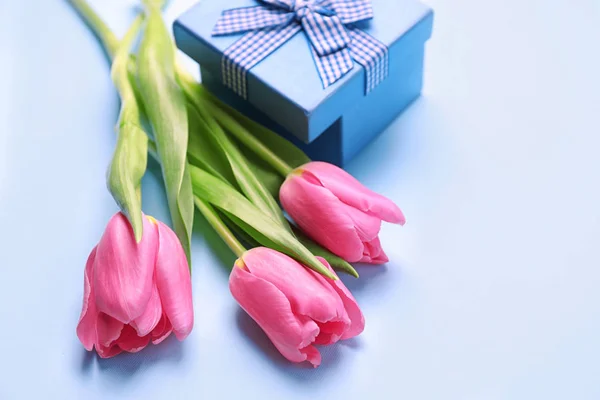 Beautiful tulips and gift box on color background — Stock Photo, Image