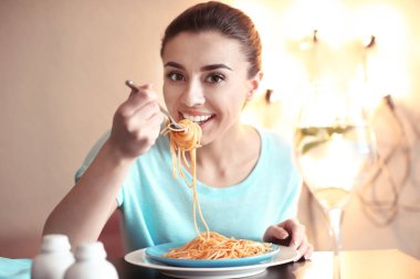 Genç kadın kafede lezzetli makarna yemek