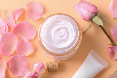 Vücut kremi ve çiçek yaprakları renk arka plan üzerinde güzel kompozisyon