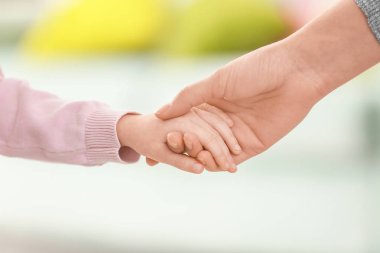 Anne ve küçük kızı üzerinde arka plan bulanık elele
