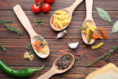 Ahşap masa üzerinde farklı pişmemiş makarna ile kompozisyon